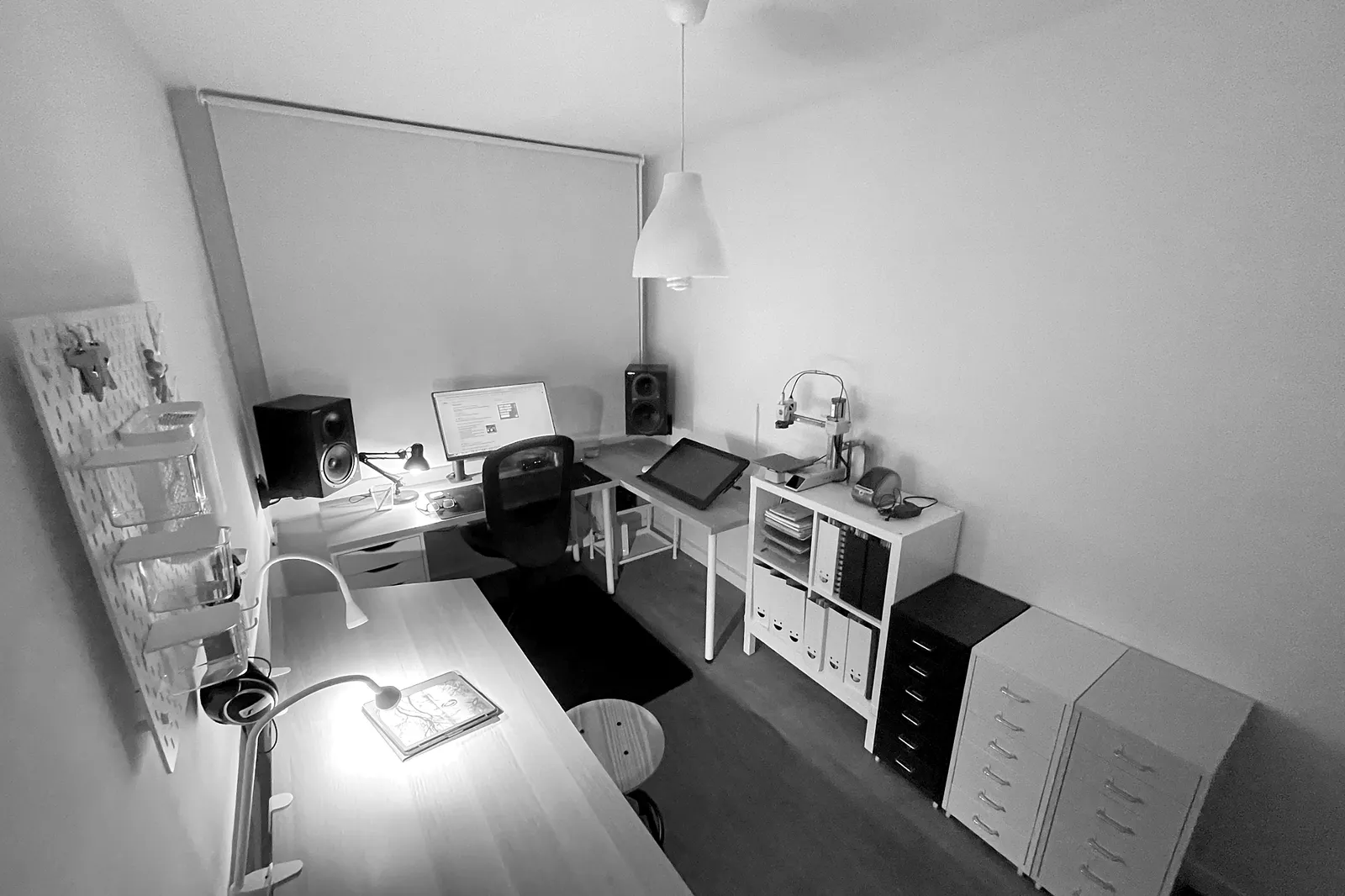 El estudio de Miguel A. Taboada en Vigo: mesa en L con monitor y altavoces, tableta de dibujo, estanterías con archivadores y cajoneras